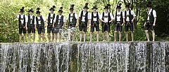Wasserfall mit traditionell angezogener Gruppe Männer